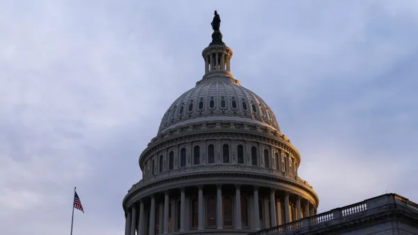 The dome of the U.S. Capitol building is shown with a U.S. flag flying on the roof.