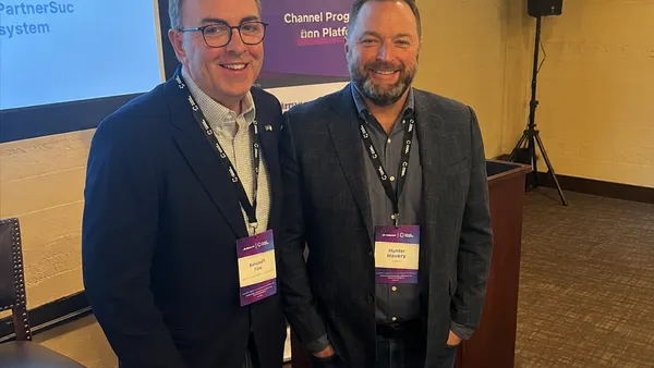 two men with conference badges smile for a photo