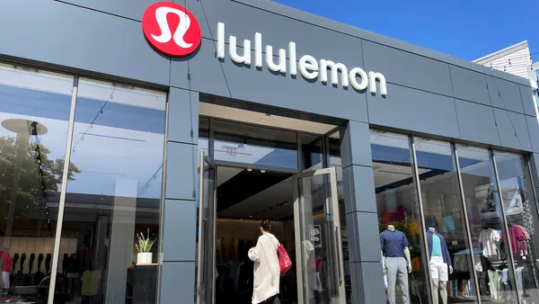 A person is seen walking into a lululemon storefront.