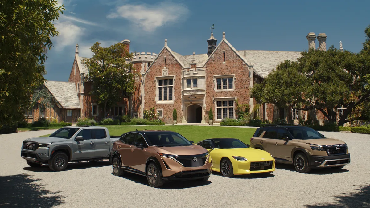 Several Nissan cars in front of the 2022 Heisman House