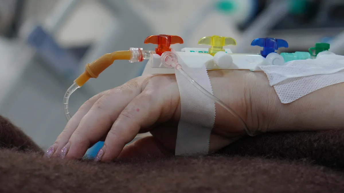 A close-up image of hand with tubes and intravenous access