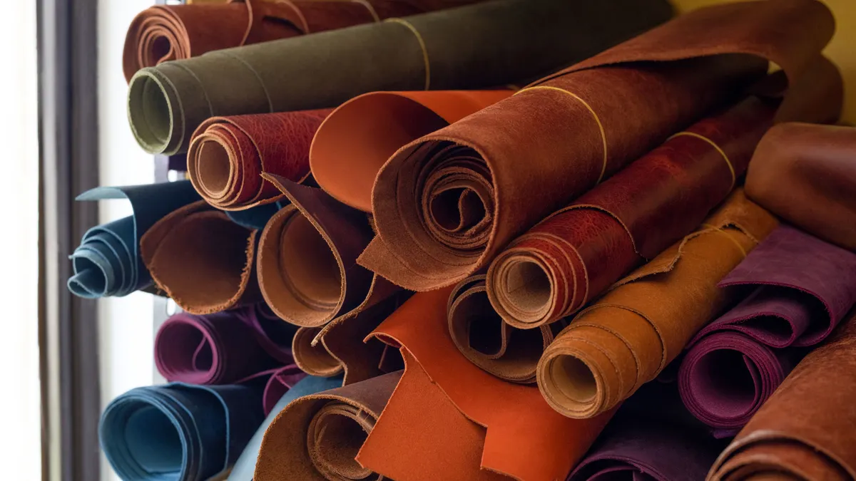Multiple rolls of leather are stacked in a pile.