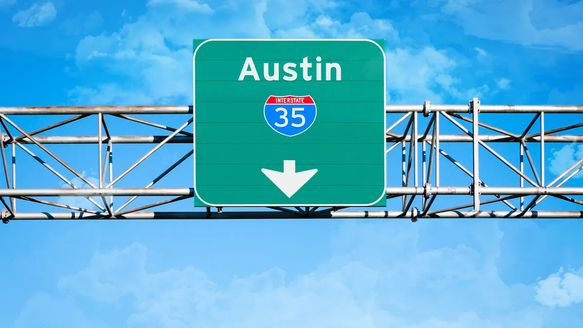 An elevated overhead highway sign that reads "Austin" and has an Interstate 35 shield above an arrow pointing downward.