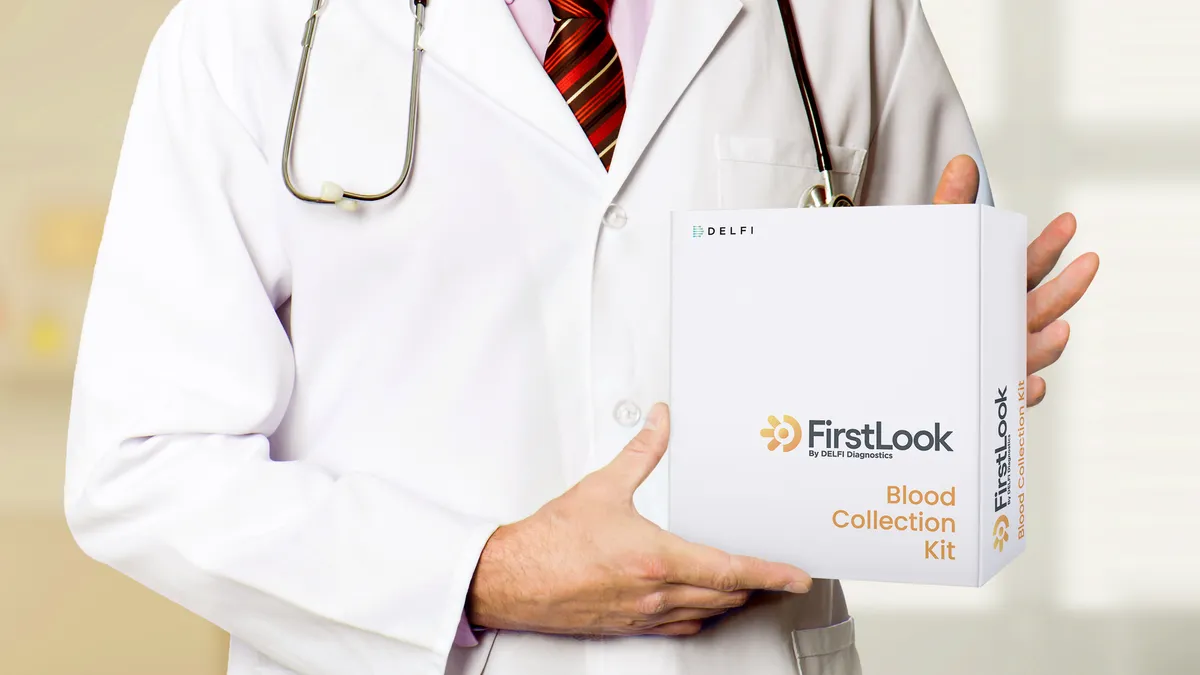 A physician holds a box containing Delfi's FirstLook Lung cancer blood test.