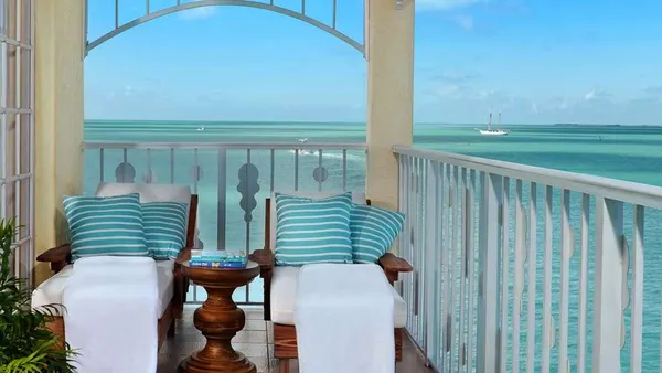 Two chairs on a deck overlooking the ocean.