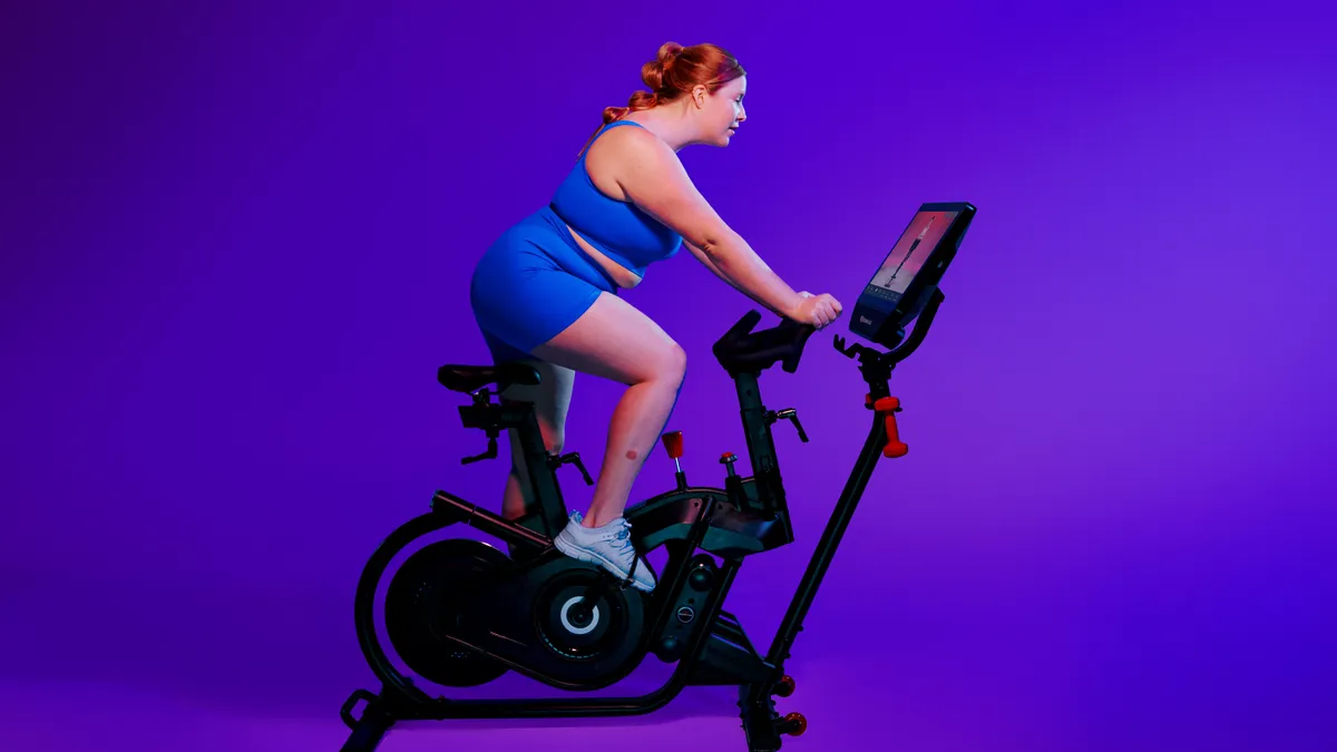 A person riding a BowFlex exercise bike.