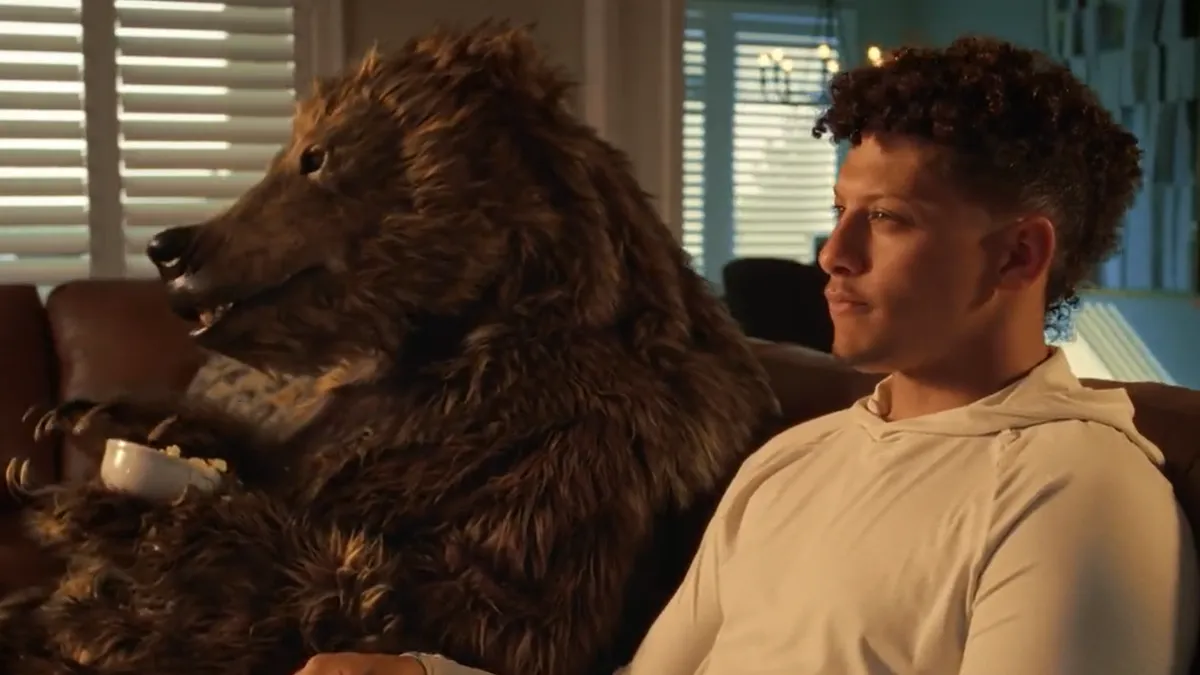 Patrick Mahomes sits with a bear.