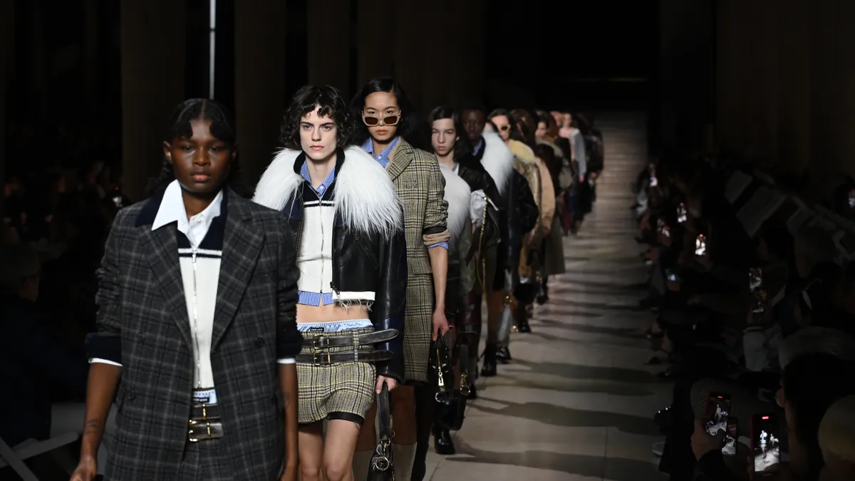 Models are lined up on the runway wearing items from Miu Miu during Paris Fashion Week.