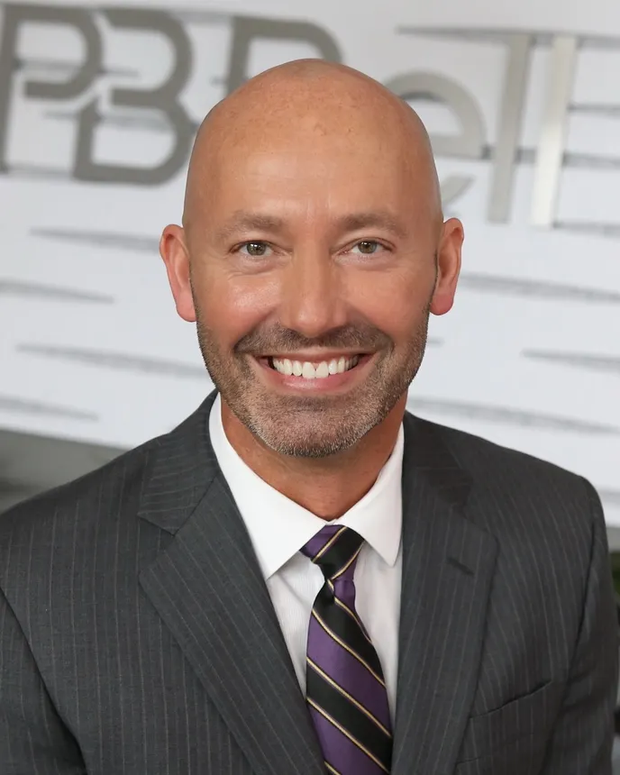 Headshot of a man in a suit.