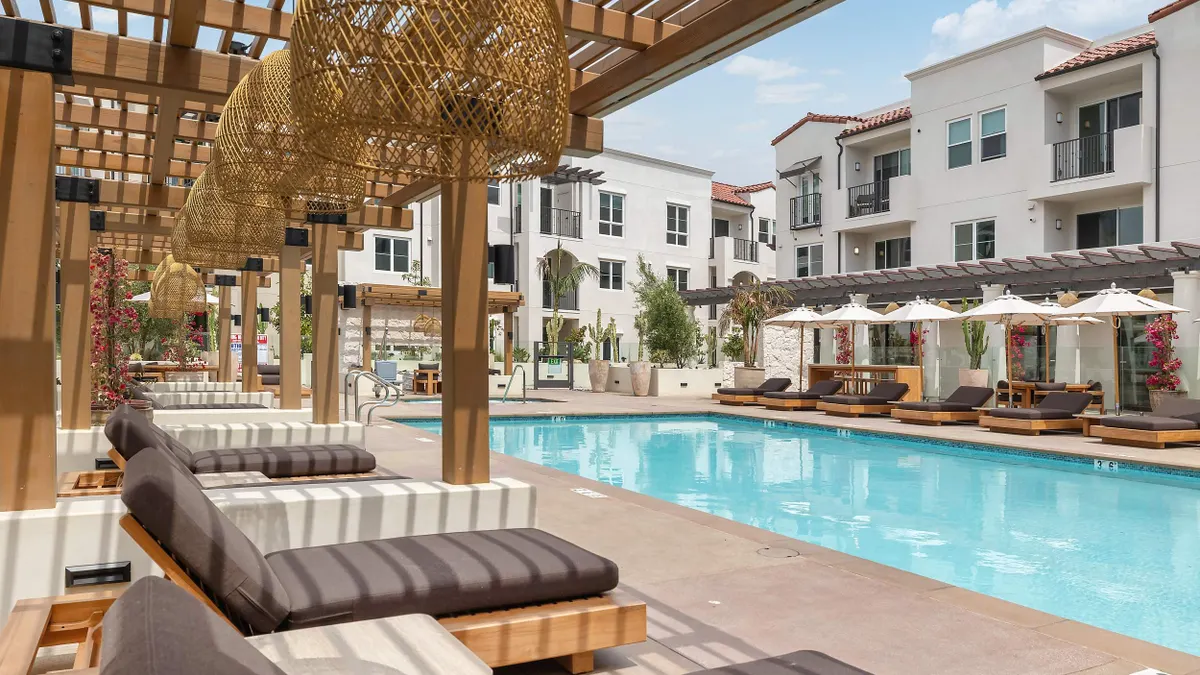 Pool with an apartment property in the background.