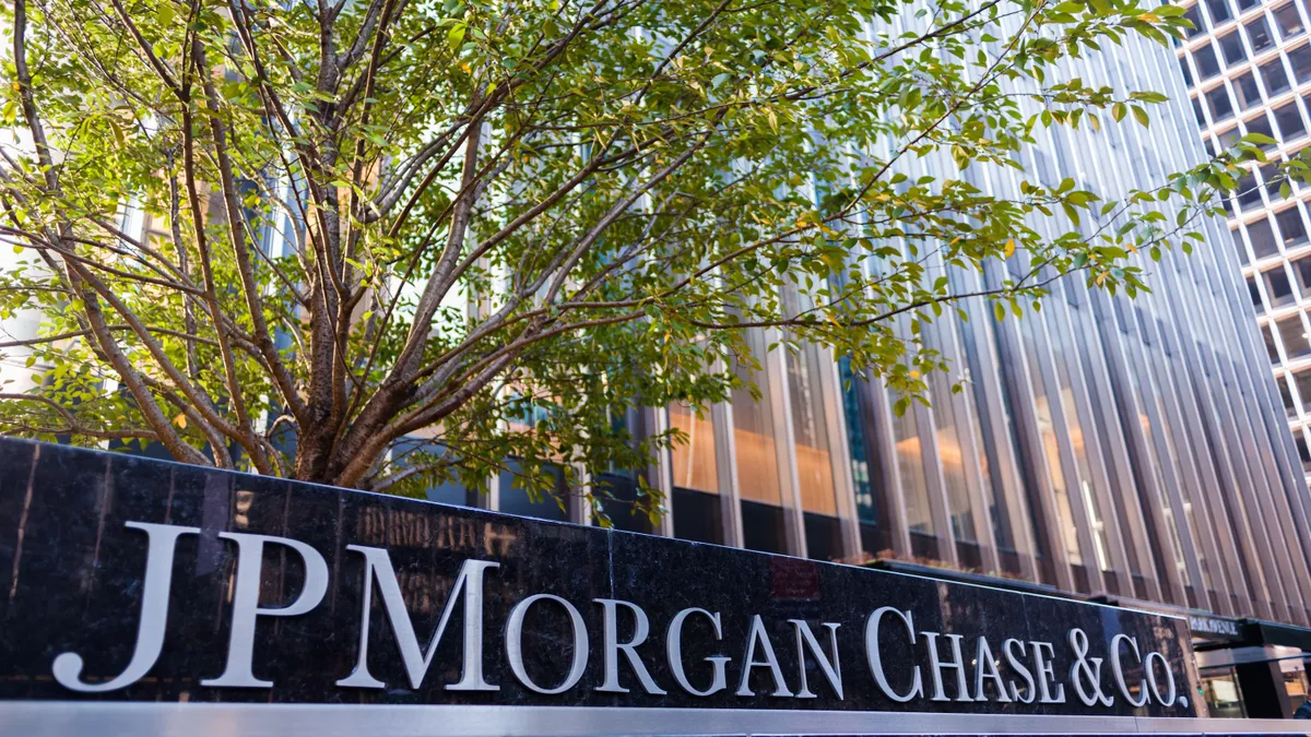 A JPMorgan Chase logo stands in front of a building on a city street.