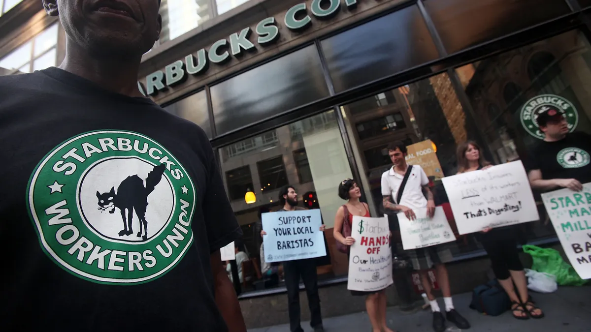 Starbucks baristas and supporters protest outside a store.