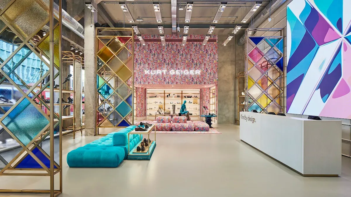 A Kurt Geiger store which features shelves of shoes and plush couches.