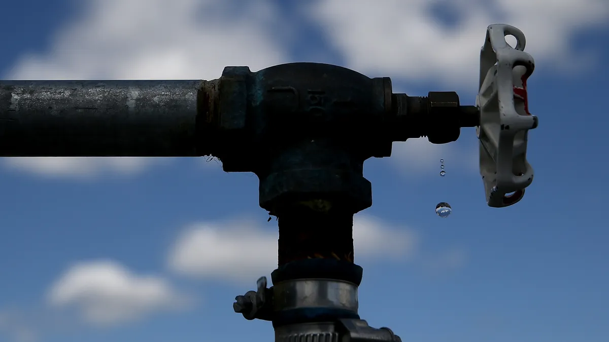 Water drips from a simple metal faucet outside.