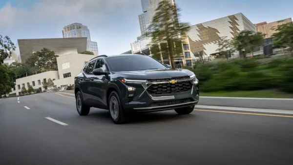 A 2026 Chevrolet Trax LT in Cypress Gray driving on a an urban road.