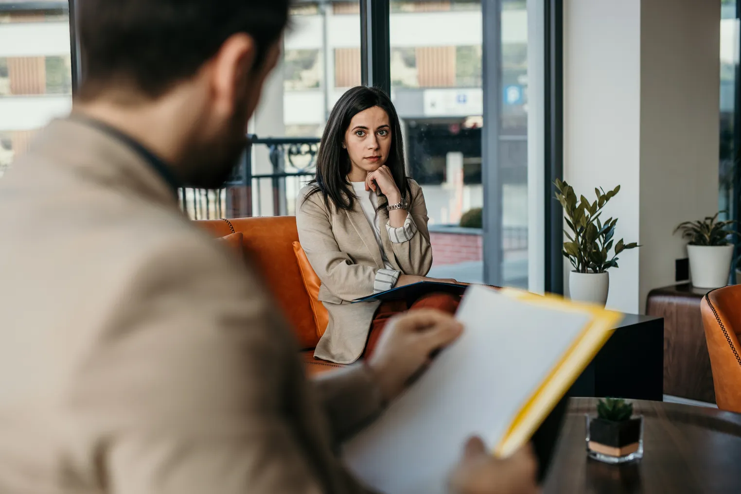 Worried person with guarded body language thinks of something while having a job interview at the corporate office