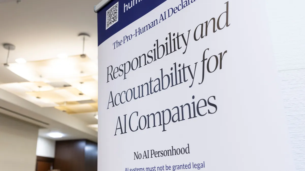 A blue and white sign is displayed in a lobby. The text reads, "Responsibility and Accountability for AI Companies."