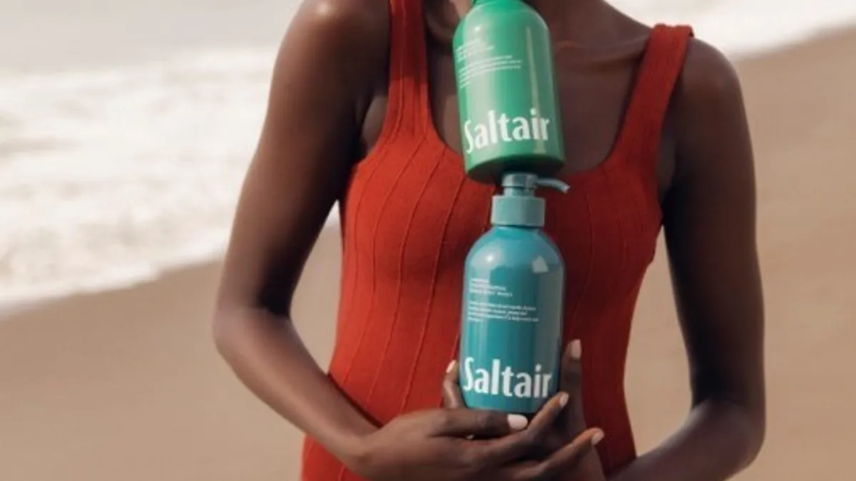 A woman holding two bottles of Saltair products