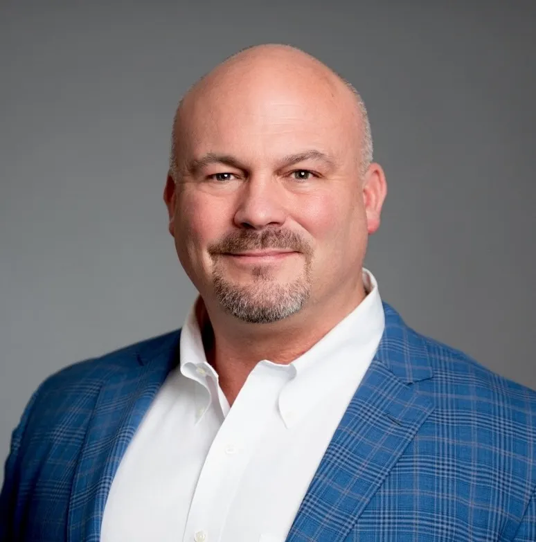 A headshot of a man wearing a suit