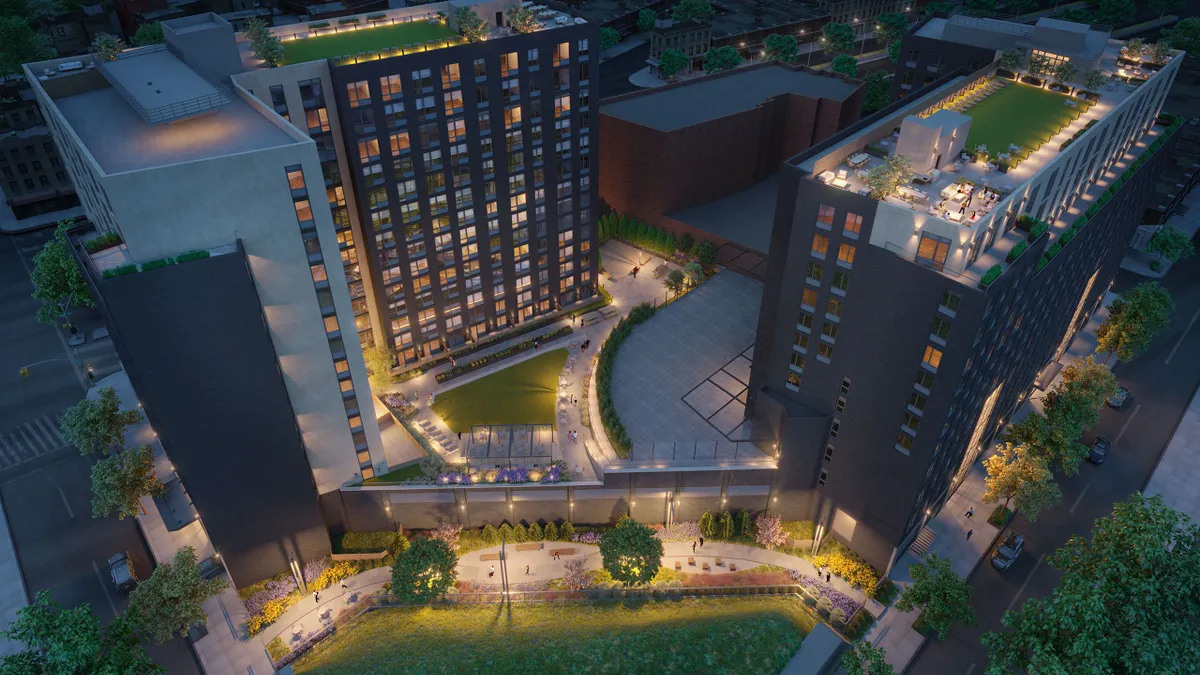 Two tall apartment towers flanking a green lawn.