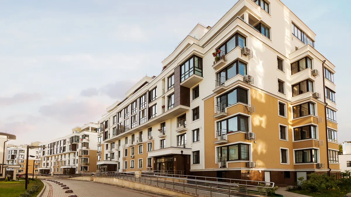 A yellow mid-rise apartment building.