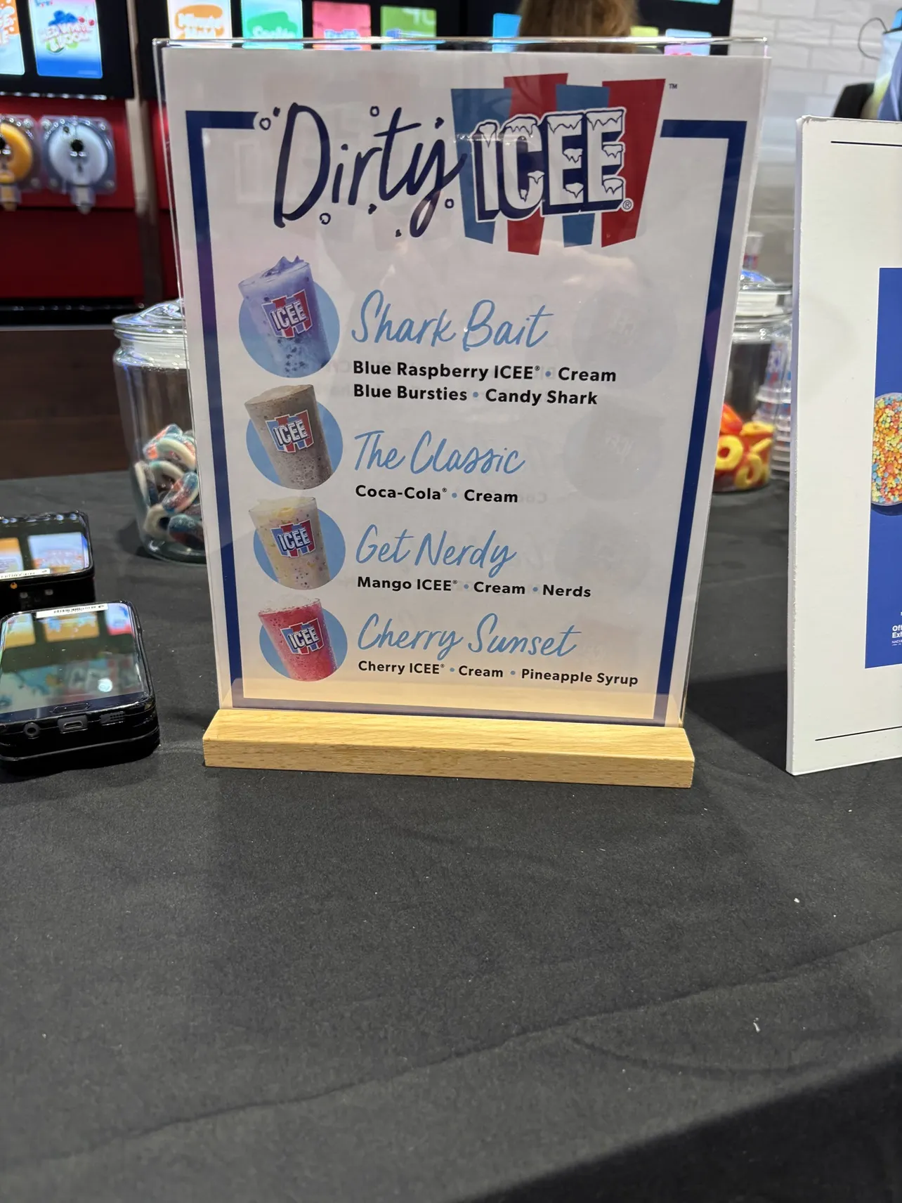 A photo of a sign showing recipes for several frozen beverages, including Shark Bait, The Classic, Get Nerdy and Cherry Sunset.