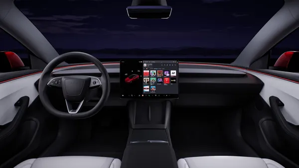 The interior of the Tesla Model 3 showing the dashboard, steering wheel and center display screen.