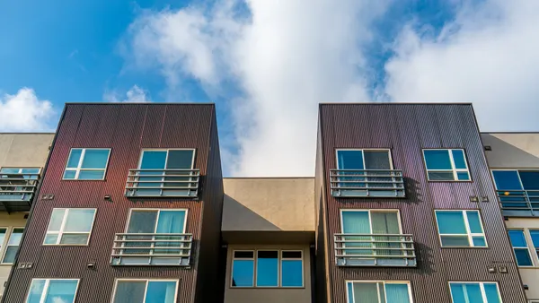 The top of a brown high-rise apartment building.