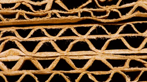 Close-up view of the edge of flattened corrugated boxes, showing the corrugating medium between the linerboard layers.