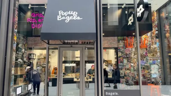 An image of a glass storefront with a sign that says "PopUp Bagels
