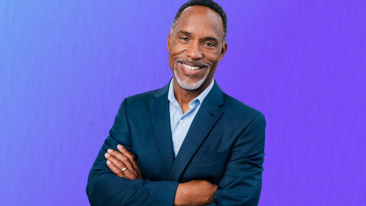 A man standing in front of purple background