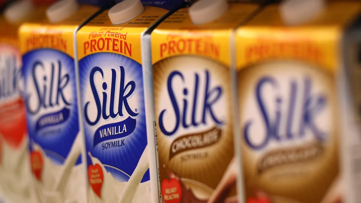 Silk milk cartons sit on grocery shelves