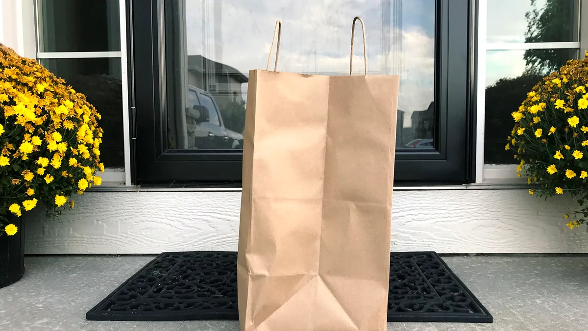 A paper bag on a front porch.