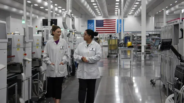 Two Ericsson employees walk inside the company’s Lewisville, Texas, factory.