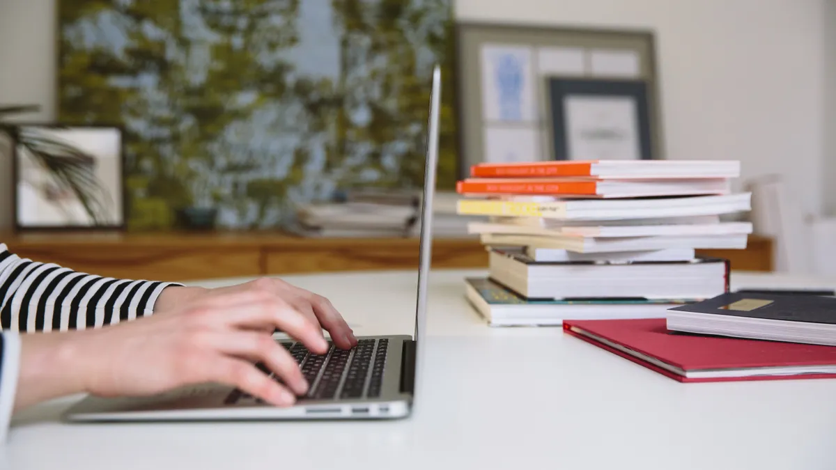 hands typing on a laptop keyboard