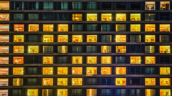 Grid of apartments glow at night.