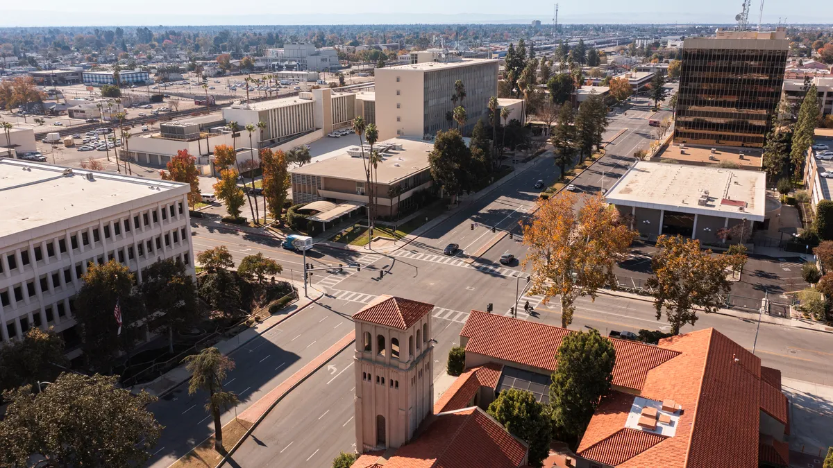 Aerial shot of intersection surrounded by buildings and trees.