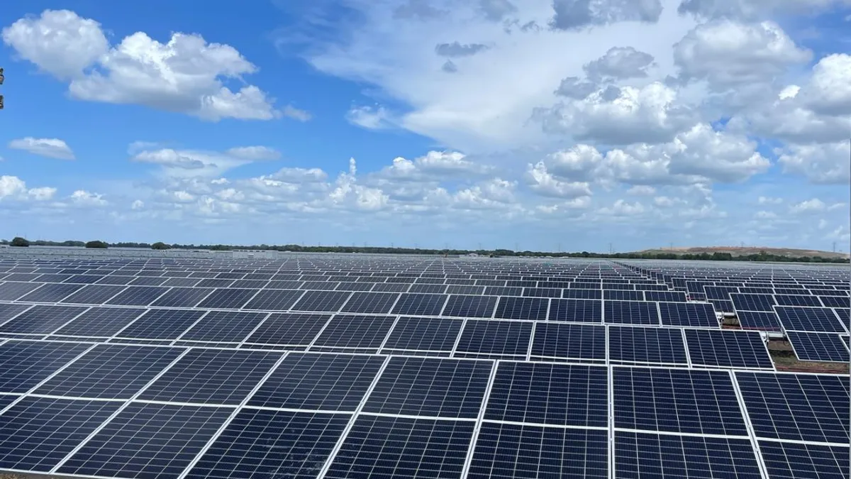 A view of solar panels on a sunny day, that stretches beyond the edges of the photo.