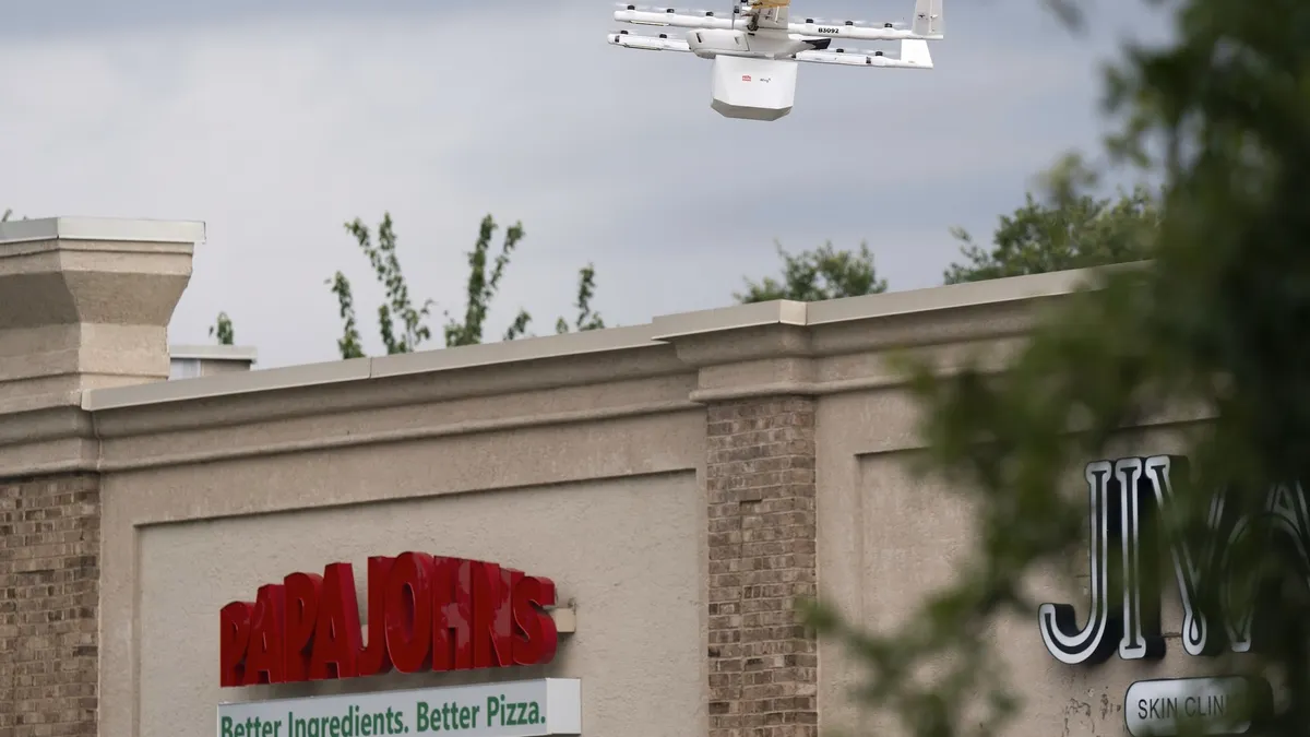 A Wing drone over a Papa Johns.