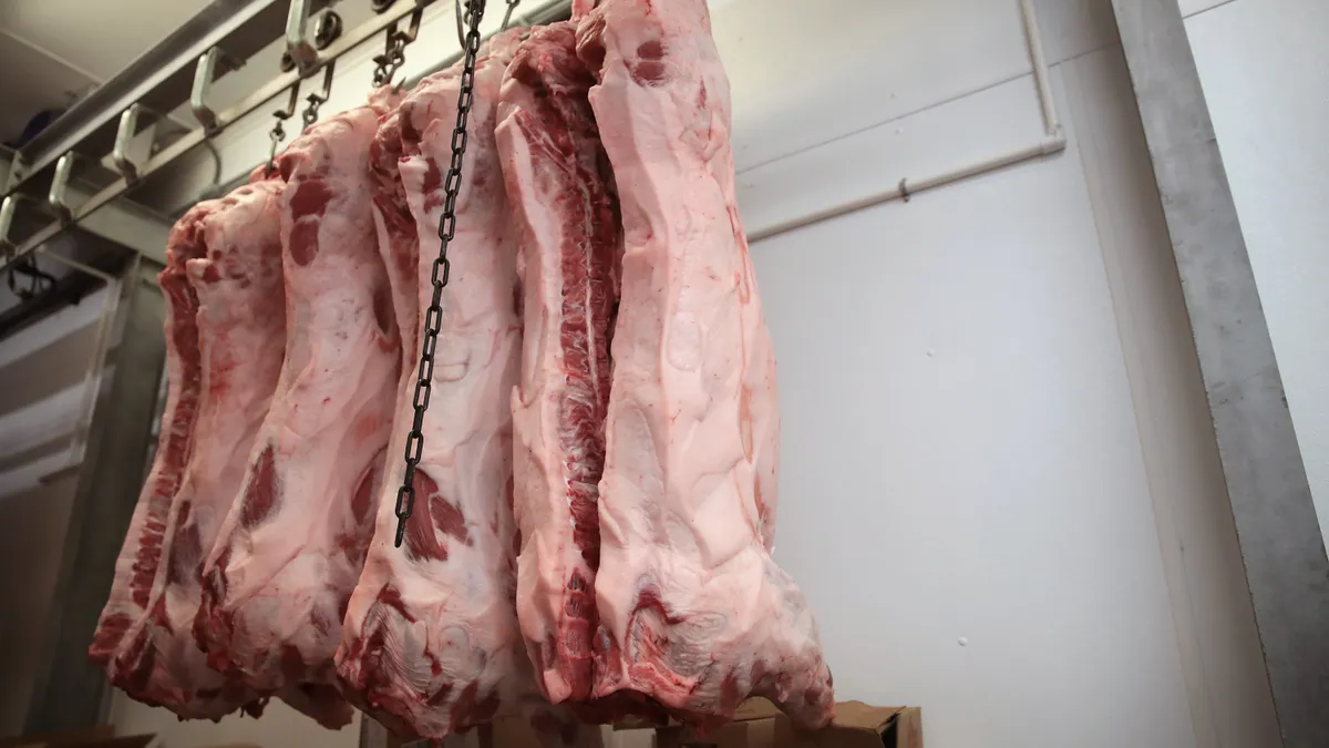 Pieces of hog meat are hung from the ceiling.