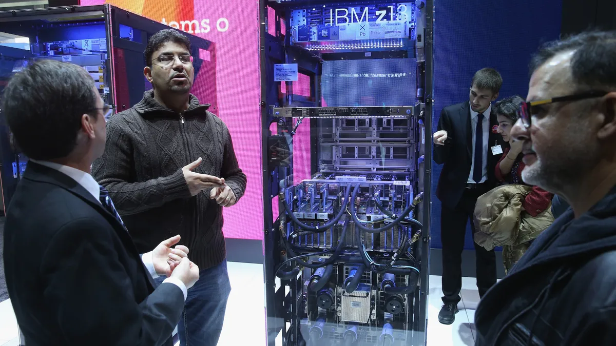 Visitors look at an IBM z13 mainframe computer at the IBM stand at the 2015 CeBIT technology trade fair on March 16, 2015 in Hanover, Germany.