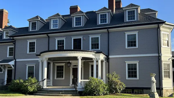 Two story colonial-style building with dormers.
