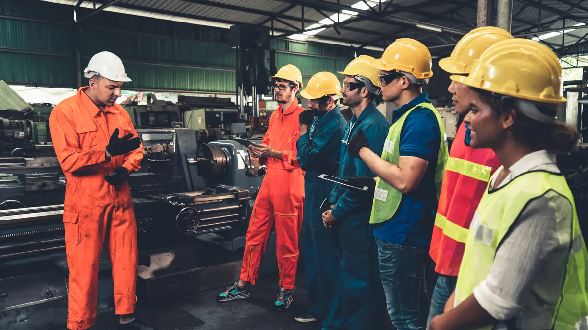 Skillful workers attending brief meeting in the factory