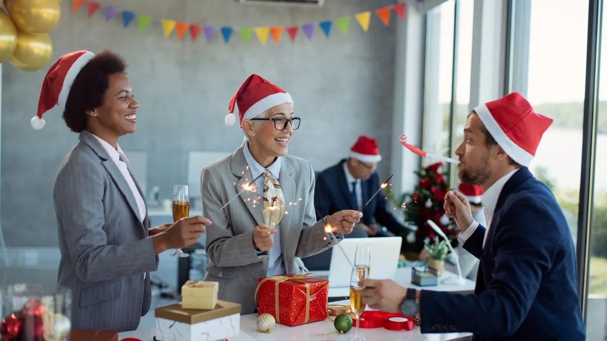 Group of happy business people celebrating and having fun with sparklers on New Year's office party.