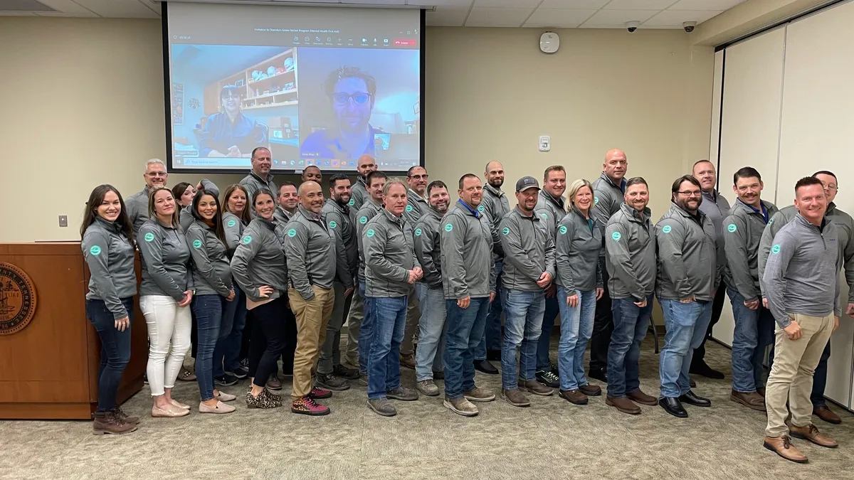 A group of people in matching fleeces pose for a photo.