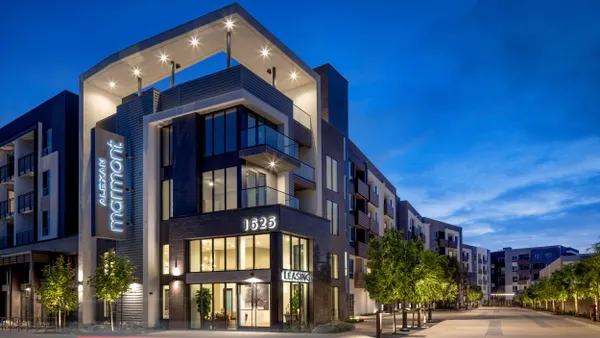 New mid-rise apartment community at dusk.