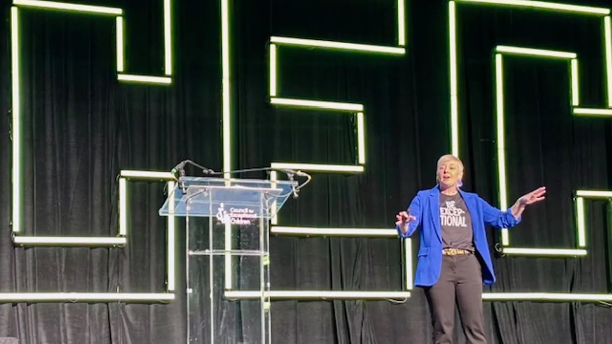 A person is on a stage. Behind them is a neon sign reading "CEC"