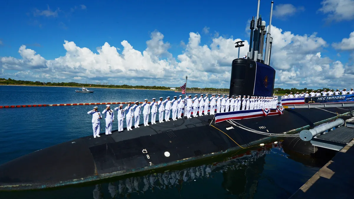 The crew of USS Indiana salute during the commissioning ceremony of the USS Indiana, s Virginia-class fast-attack submarine