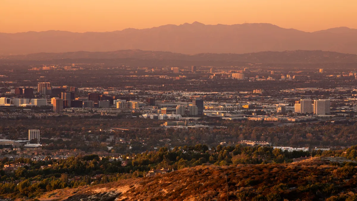 The Anaheim and Santa Ana skylines as seen from a distance at sunset.