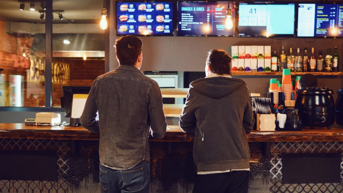 Two people ordering food at a counter